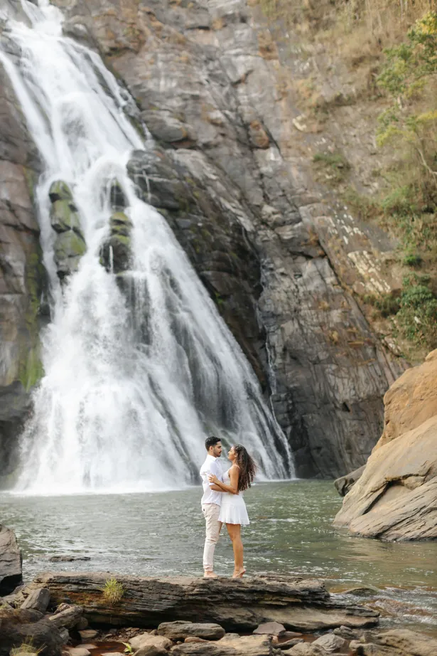Casal diante de uma cachoeira